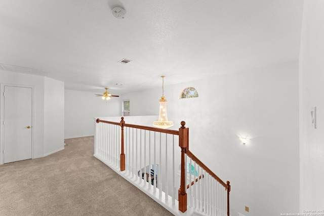 hallway with carpet, an upstairs landing, and visible vents