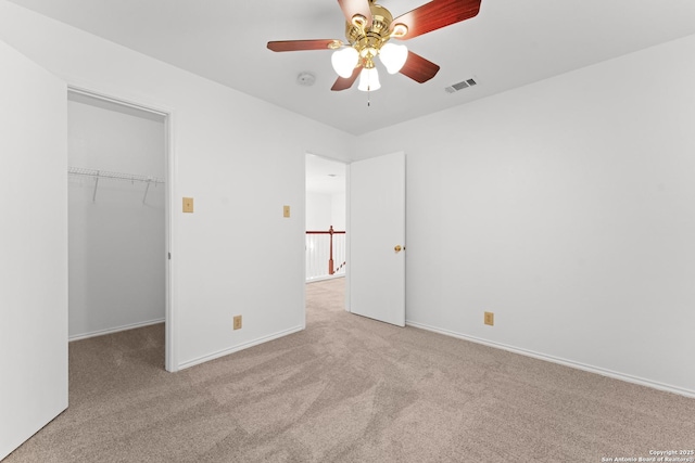 unfurnished bedroom featuring carpet floors, baseboards, a spacious closet, visible vents, and a closet