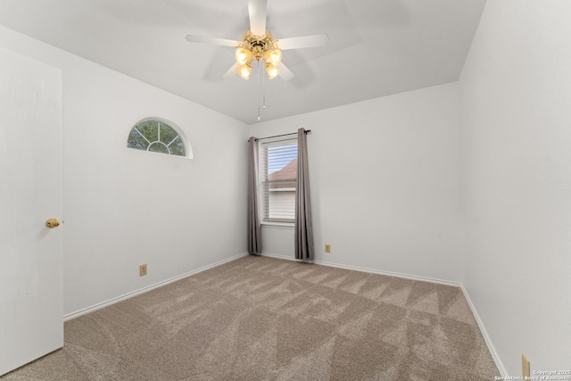 carpeted spare room with ceiling fan and baseboards