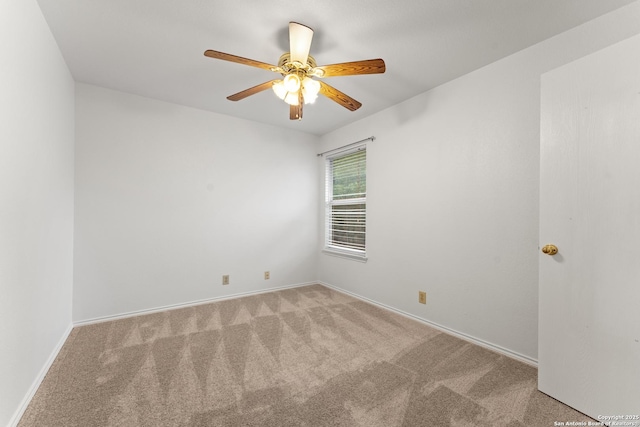 carpeted empty room with ceiling fan and baseboards