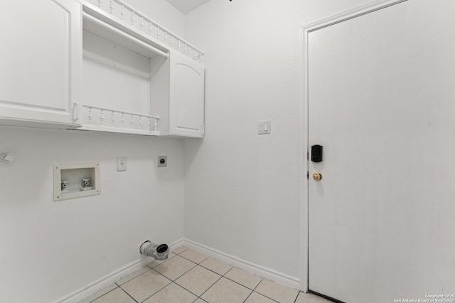 clothes washing area with electric dryer hookup, cabinet space, light tile patterned floors, baseboards, and hookup for a washing machine