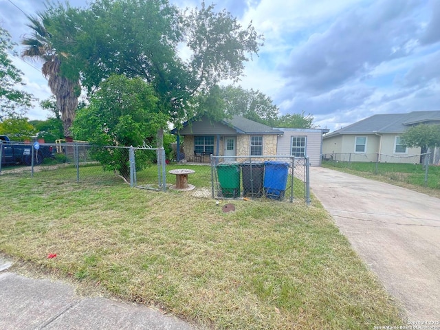 bungalow-style home with fence private yard, a front lawn, and driveway