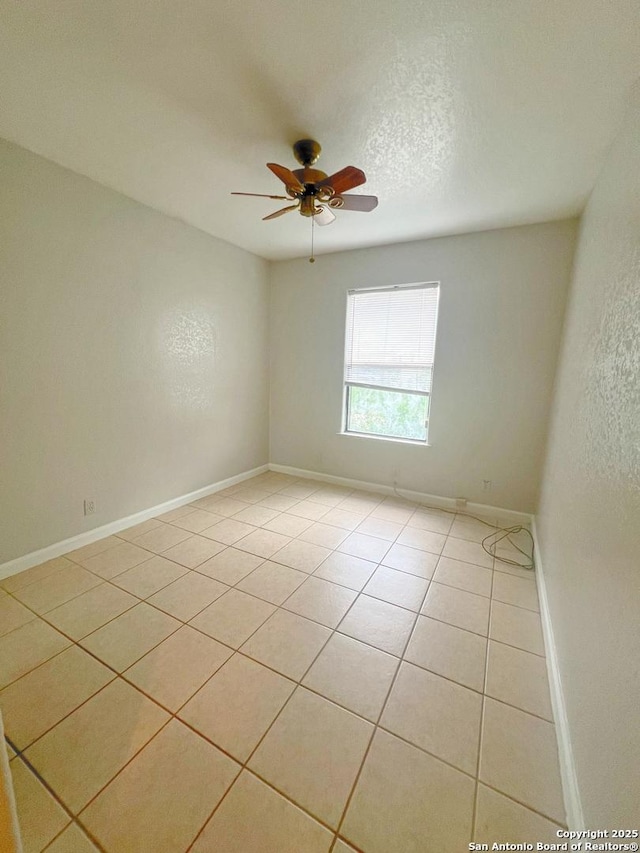 unfurnished room with light tile patterned floors, baseboards, and a ceiling fan
