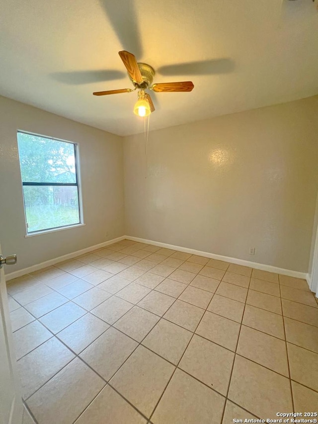 unfurnished room with baseboards, ceiling fan, and light tile patterned floors