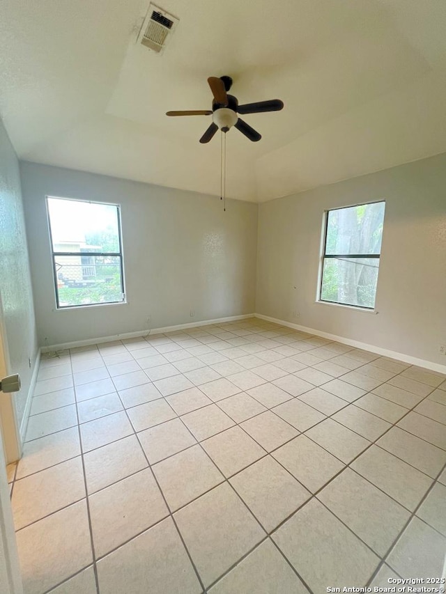 empty room featuring light tile patterned flooring, visible vents, and a wealth of natural light