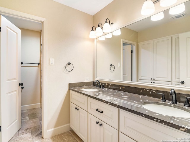 105 Sheffield, San Antonio, TX 78213 - bathroom with baseboards, double vanity, and stone finish flooring