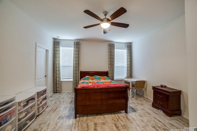 bedroom featuring baseboards, a ceiling fan, and wood finished floors