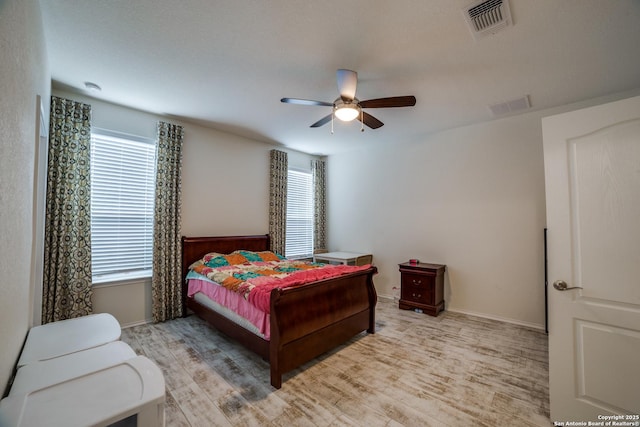 bedroom featuring visible vents, multiple windows, and light wood-style flooring