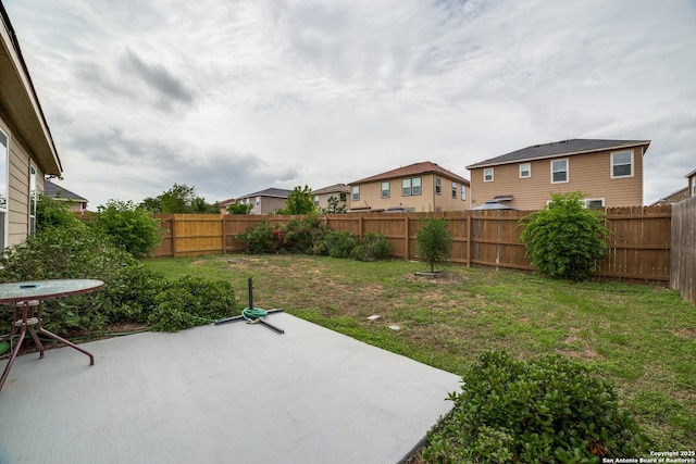 view of yard with a patio, a fenced backyard, and a residential view