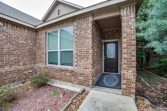 entrance to property featuring brick siding