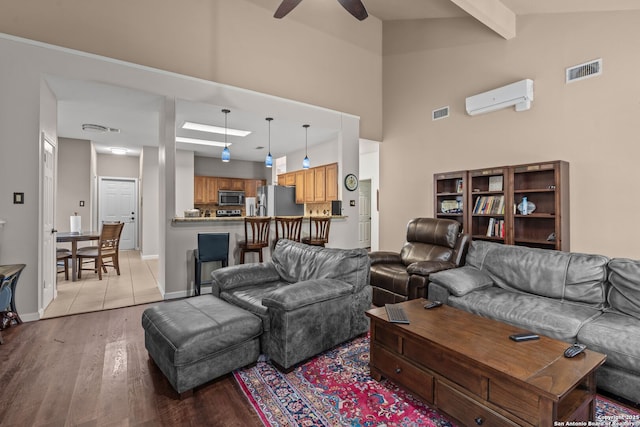 17926 Autumn Knl, San Antonio, TX 78258 - living room with visible vents, light wood-style floors, a wall mounted AC, a ceiling fan, and vaulted ceiling with beams
