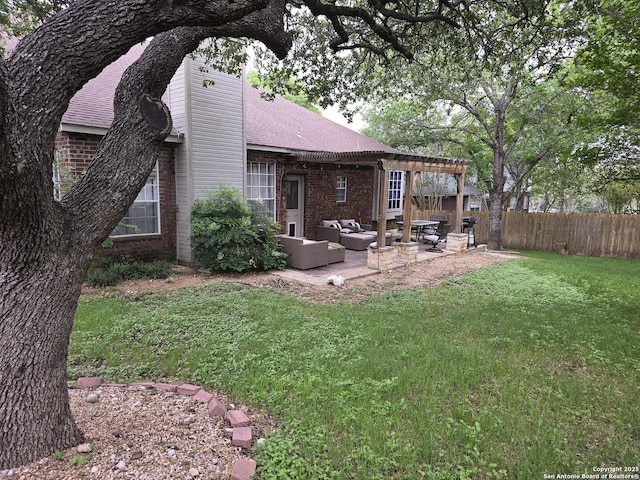 rear view of property with fence, brick siding, outdoor lounge area, a patio area, and a lawn