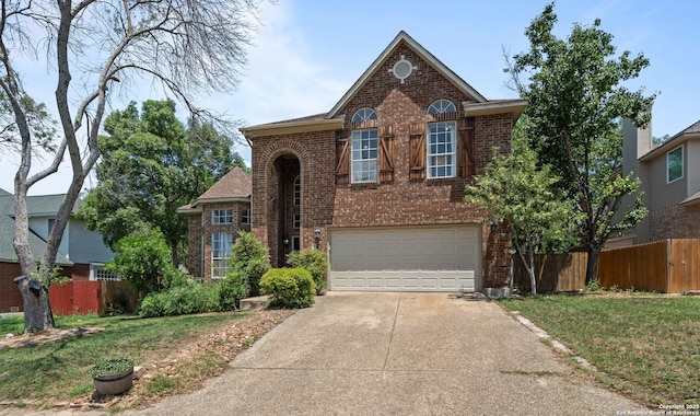 17926 Autumn Knl, San Antonio, TX 78258 - traditional-style house featuring a garage, fence, a front yard, brick siding, and driveway