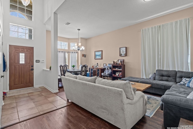 17926 Autumn Knl, San Antonio, TX 78258 - living area featuring a high ceiling, visible vents, baseboards, tile patterned flooring, and a chandelier