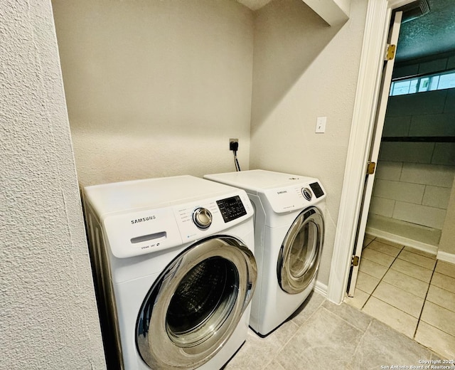 washroom with laundry area, light tile patterned floors, and washing machine and clothes dryer