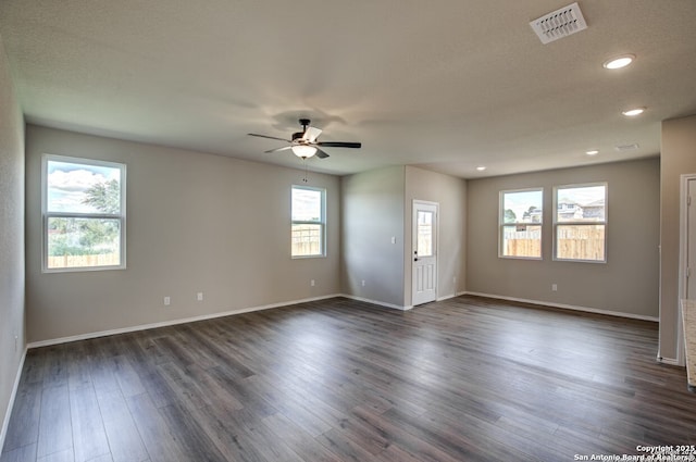empty room with ceiling fan, recessed lighting, baseboards, dark wood-type flooring, and visible vents