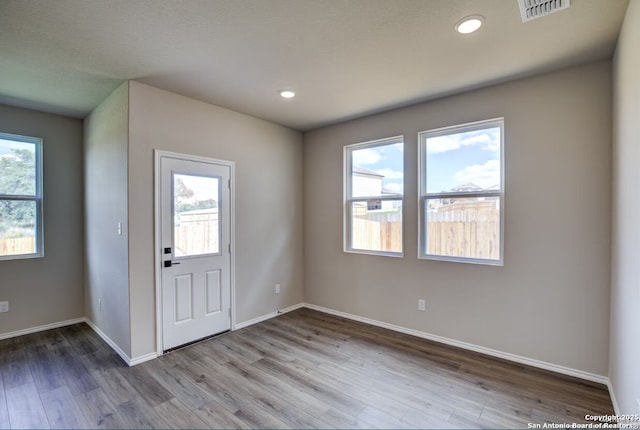 foyer featuring recessed lighting, baseboards, visible vents, and wood finished floors