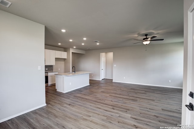 kitchen with ceiling fan, visible vents, baseboards, open floor plan, and recessed lighting