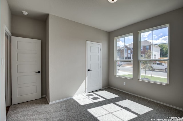 unfurnished bedroom featuring carpet floors and baseboards