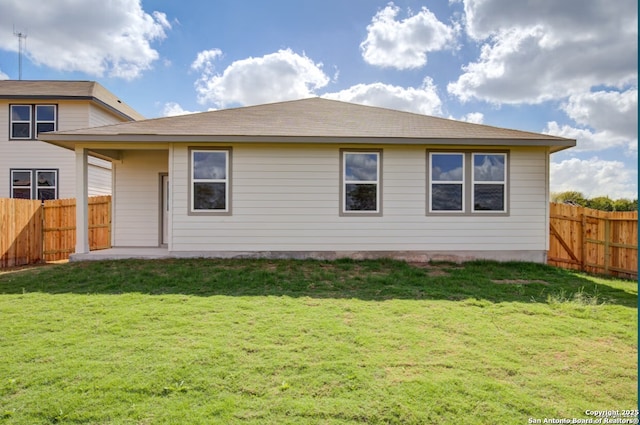 back of property featuring a fenced backyard and a yard