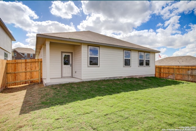 back of house featuring a fenced backyard and a yard