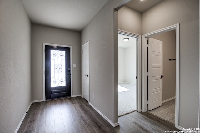 entryway featuring baseboards and wood finished floors