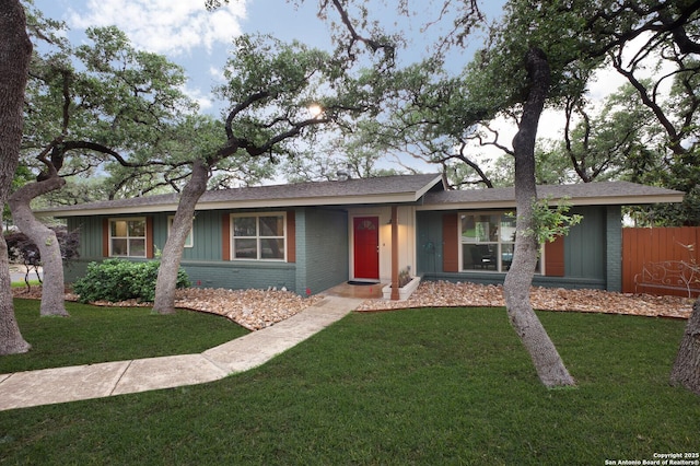 ranch-style house with brick siding, board and batten siding, and a front yard