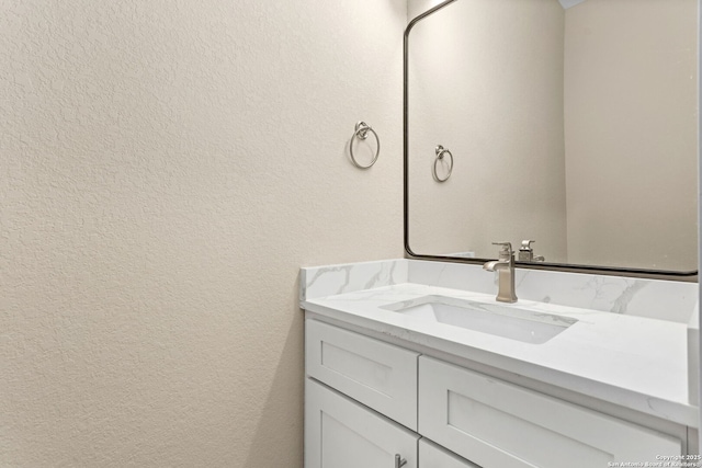 bathroom with vanity and a textured wall