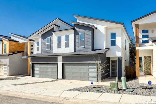 contemporary house with concrete driveway, fence, and a garage