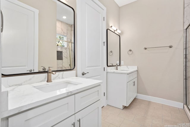 bathroom with baseboards, two vanities, a sink, and a stall shower