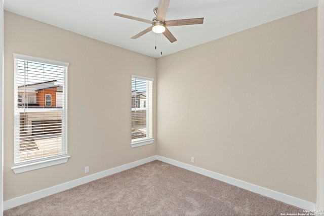 empty room with baseboards, ceiling fan, and light carpet