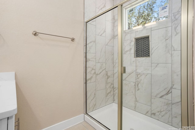 bathroom featuring baseboards, tile patterned flooring, and a stall shower