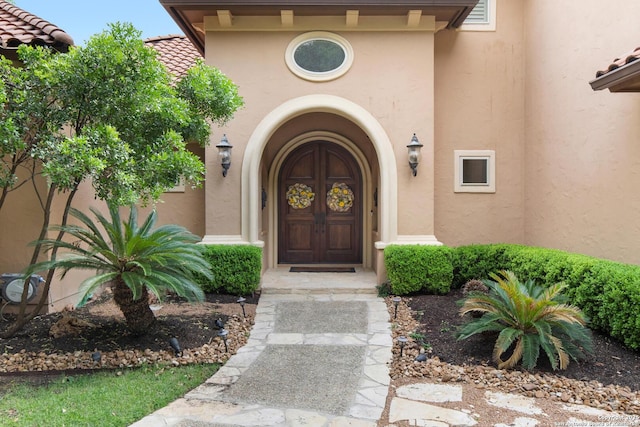 entrance to property featuring stucco siding