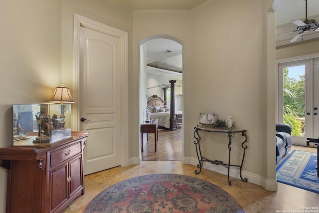 entrance foyer featuring arched walkways, ceiling fan, visible vents, and baseboards