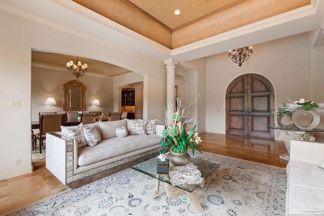 living area featuring crown molding, arched walkways, baseboards, and a notable chandelier