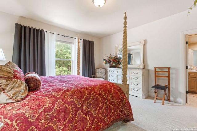 carpeted bedroom with connected bathroom and baseboards