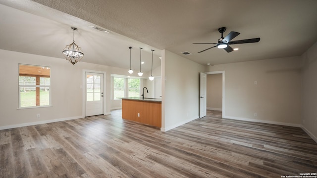 5806 Gillis, San Antonio, TX 78240 - unfurnished living room featuring a sink, visible vents, baseboards, wood finished floors, and vaulted ceiling