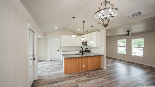 5806 Gillis, San Antonio, TX 78240 - kitchen with visible vents, a peninsula, light wood-style floors, open floor plan, and stainless steel microwave