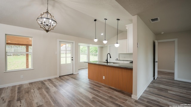 5806 Gillis, San Antonio, TX 78240 - kitchen with visible vents, wood finished floors, baseboards, a sink, and vaulted ceiling