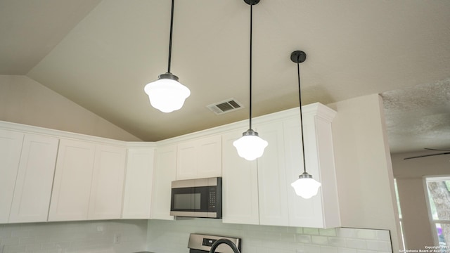 5806 Gillis, San Antonio, TX 78240 - details with visible vents, pendant lighting, stove, white cabinetry, and stainless steel microwave