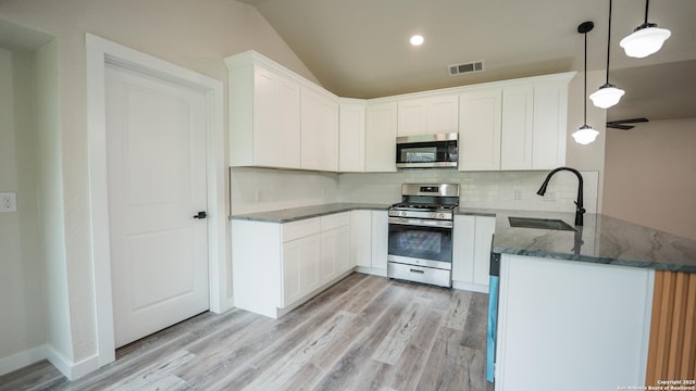 5806 Gillis, San Antonio, TX 78240 - kitchen featuring appliances with stainless steel finishes, a sink, dark stone counters, light wood-type flooring, and visible vents