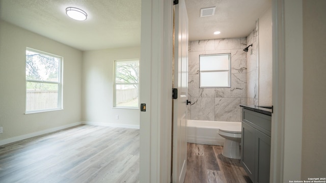 5806 Gillis, San Antonio, TX 78240 - bathroom featuring visible vents, wood finished floors, vanity, toilet, and bathing tub / shower combination