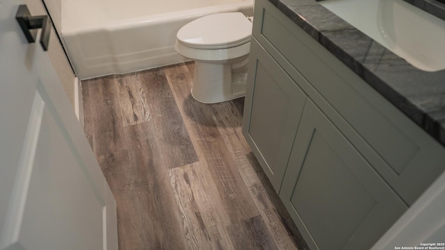 5806 Gillis, San Antonio, TX 78240 - bathroom featuring a bathing tub, toilet, wood finished floors, and vanity