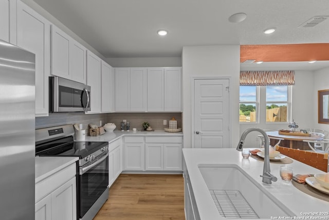 kitchen featuring a sink, white cabinetry, appliances with stainless steel finishes, and light countertops