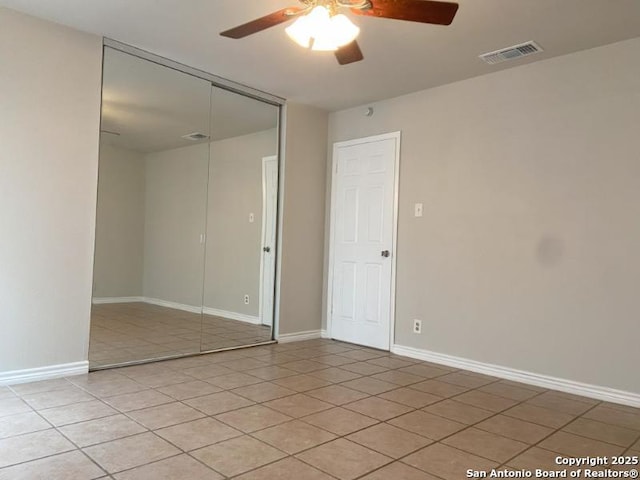 spare room featuring visible vents, a ceiling fan, baseboards, and light tile patterned floors