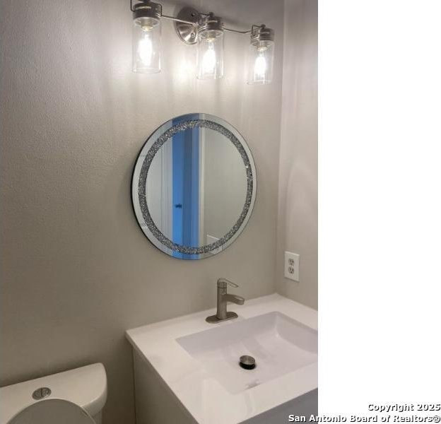 half bathroom with toilet and vanity
