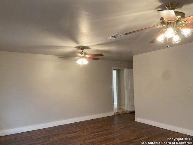 empty room with ceiling fan, visible vents, baseboards, and wood finished floors