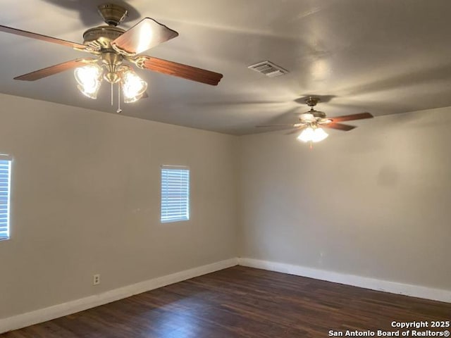 spare room with a healthy amount of sunlight, baseboards, ceiling fan, and visible vents