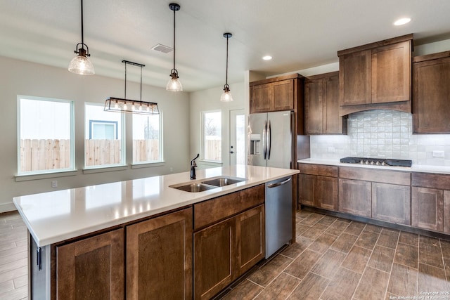 kitchen with light countertops, stainless steel appliances, visible vents, and a sink