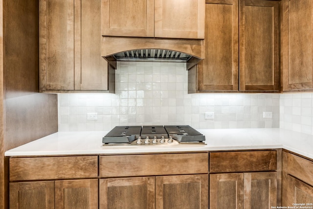 kitchen featuring stainless steel gas cooktop, backsplash, and light countertops